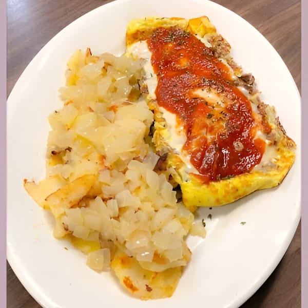 A breakfast plate with a cheesy omelet topped with salsa and a side of diced potatoes.